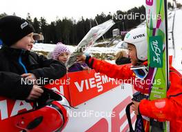 22.12.2013, Hinterzarten, Germany (GER): Sara Takanashi (JPN) gives the flowers to the kids - FIS world cup ski jumping ladies, individual HS106, Hinterzarten (GER). www.nordicfocus.com. © Laiho/NordicFocus. Every downloaded picture is fee-liable.