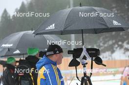 13.01.2011, Ruhpolding, Germany (GER): Gerald Hoenig (GER), Coach Team Germany, Ricco Gross (GER) Coach Team Germany and Staffan Eklund (SWE), coach Sweden wait under the umbrellas - IBU world cup biathlon, individual women, Ruhpolding (GER). www.nordicfocus.com. © Manzoni/NordicFocus. Every downloaded picture is fee-liable.