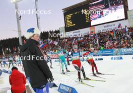 11.03.2011, Khanty-Mansiysk, Russia (RUS): Chief of Competition watches Simon Eder (AUT), Fischer, Rottefella, Swix and Ole Einar Bjoerndalen (NOR), Madshus, Rottefella, Odlo - IBU world championships biathlon, relay men, Khanty-Mansiysk (RUS). www.nordicfocus.com. © Manzoni/NordicFocus. Every downloaded picture is fee-liable.