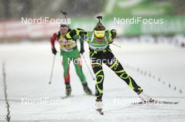 03.12.2011, Oestersund, Sweden (SWE): Mario Dolder (SUI), Rossignol, Rottefella, Leki, ODLO leads Darya Domracheva (BLR), Fischer, Rottefella, Leki - IBU world cup biathlon, sprint women, Oestersund (SWE). www.nordicfocus.com. © Manzoni/NordicFocus. Every downloaded picture is fee-liable.