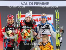 09.01.2011, Val di Fiemme, Italy (ITA): podium Tour de Ski overall, l-r: 2nd Therese Johaug (NOR), Fischer, Salomon, Swix, jJustyna Kowalczyk (POL), Fischer, Salomon, Swix, Marianna Longa (ITA), Fischer, Salomon, One Way  - FIS world cup cross-country, tour de ski, final climb women, Val di Fiemme (ITA). www.nordicfocus.com. © Hemmersbach/NordicFocus. Every downloaded picture is fee-liable.