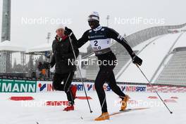23.02.2011, Oslo, Norway (NOR):  (l-r) the ski legend Bjoern Daehlie running beside Philip Boit (KEN) - FIS nordic world ski championships, cross-country, Individual Classic Qualification Race, Oslo (NOR). www.nordicfocus.com. © Laiho/NordicFocus. Every downloaded picture is fee-liable.