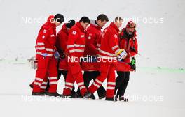 16.12.2012, Ramsau, Austria (AUT):  Carlos Kammerlander (AUT) fell during his competition jump and was carried by first aid crew - FIS world cup nordic combined, individual gundersen HS98/10km, Ramsau (AUT). www.nordicfocus.com. © Laiho/NordicFocus. Every downloaded picture is fee-liable.