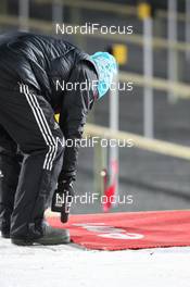 27.11.2013, Oestersund, Sweden (SWE): Biathlon Feature: volunteer try to fix the shooting mats - IBU world cup biathlon, individual women, Oestersund (SWE). www.nordicfocus.com. © Manzoni/NordicFocus. Every downloaded picture is fee-liable.