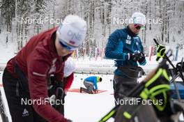 15.01.2019, Ruhpolding, Germany (GER): Event Feature: a volunteer fixes the shooting mats while the Norwegian team waits for training -  IBU world cup biathlon, training, Ruhpolding (GER). www.nordicfocus.com. © Manzoni/NordicFocus. Every downloaded picture is fee-liable.