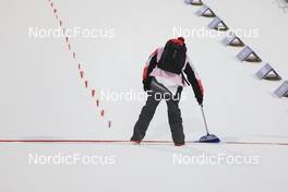 05.02.2022, Beijing, China (CHN): Event Feature: volunteer cleans the finish line - XXIV. Olympic Winter Games Beijing 2022, Biathlon, mixed relay, Beijing (CHN). www.nordicfocus.com. © Manzoni/NordicFocus. Every downloaded picture is fee-liable.