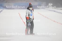 13.02.2022, Beijing, China (CHN): Event Feature: Volunteer cleans the finish line - XXIV. Olympic Winter Games Beijing 2022, Biathlon, pursuit men, Beijing (CHN). www.nordicfocus.com. © Manzoni/NordicFocus. Every downloaded picture is fee-liable.